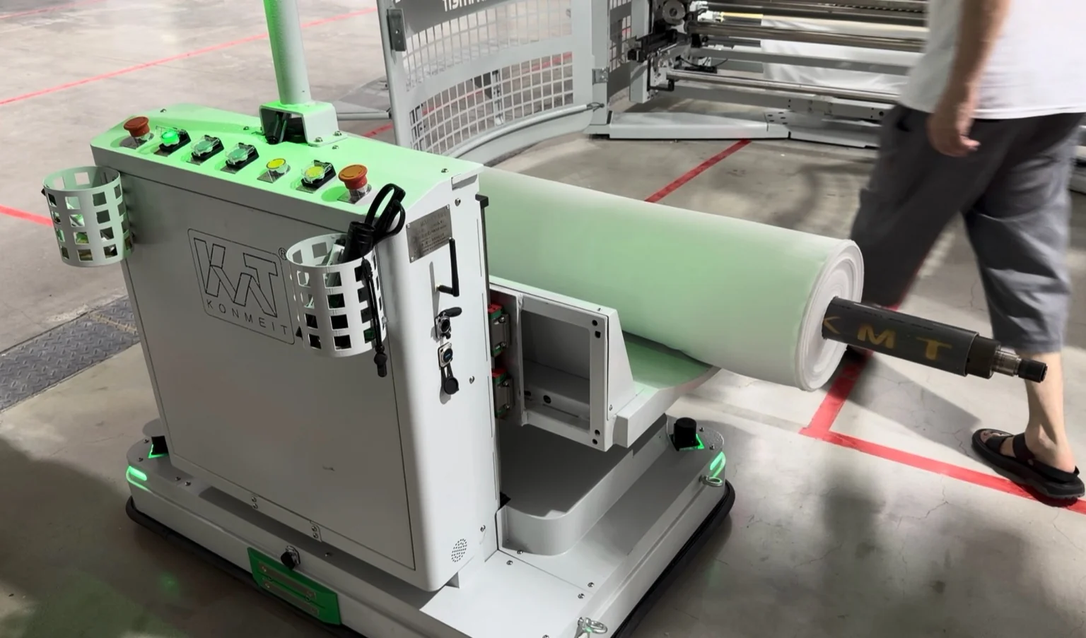 Fabric rolls and a person handling a finished roll
