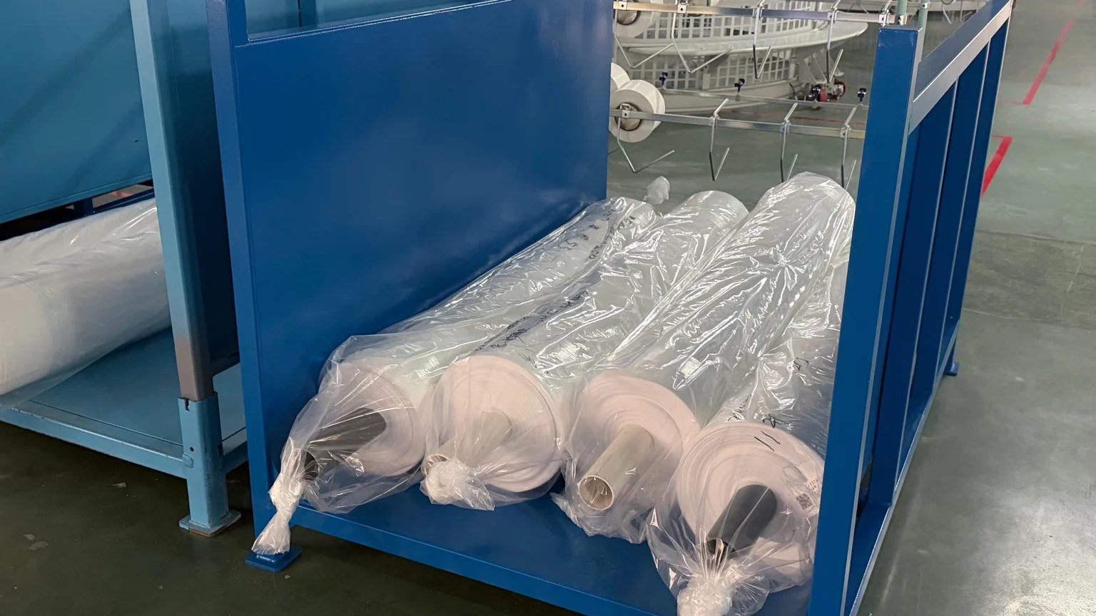 Fabric rolls and a person handling a finished roll